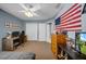 This bedroom has a ceiling fan, neutral carpet, desk and chair, and a flag on the wall at 17124 Falconridge Rd, Lithia, FL 33547