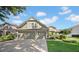 Charming two-story home with a well-maintained lawn and a three-car garage on a sunny day at 17124 Falconridge Rd, Lithia, FL 33547