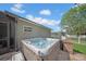 Exterior view of a modern hot tub installed on a brick patio surrounded by lush landscaping at 17124 Falconridge Rd, Lithia, FL 33547