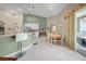 Open-concept kitchen and dining area with white cabinets, stainless steel appliances, and a breakfast bar at 17124 Falconridge Rd, Lithia, FL 33547