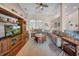 Bright living room featuring a wooden entertainment center, high ceilings, ceiling fan, and a comfortable sectional sofa at 17124 Falconridge Rd, Lithia, FL 33547