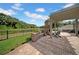 Outdoor patio featuring a brick fireplace, pergola, and views of the backyard and pond at 17124 Falconridge Rd, Lithia, FL 33547