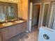 Bathroom featuring double sinks, vanity, walk-in shower, and a soaking tub at 1765 Oak Pond Ct, Oldsmar, FL 34677