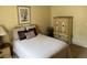 Bedroom displays bed with neutral linens, decorative pillows, and a matching armoire at 1765 Oak Pond Ct, Oldsmar, FL 34677