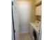 Laundry room showing a white washer and dryer with a storage cabinet above at 1765 Oak Pond Ct, Oldsmar, FL 34677