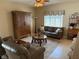 Comfortable living room with a ceiling fan, armoire, sofa, and an area rug over the tile floor at 1765 Oak Pond Ct, Oldsmar, FL 34677