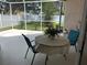 Screened patio with a table and chairs overlooking a backyard with a white privacy fence at 1765 Oak Pond Ct, Oldsmar, FL 34677