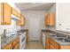 Traditional kitchen featuring wood cabinets, granite counters, and white appliances at 18017 Villa Creek Dr # 18017, Tampa, FL 33647