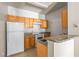 Bright kitchen showcasing wooden cabinets, white appliances and granite countertops at 18017 Villa Creek Dr # 18017, Tampa, FL 33647