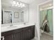 A bathroom with dual vanity, large mirror, and a shower with a shark shower curtain at 18219 Ramble On Way, Land O Lakes, FL 34638