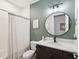 Stylish bathroom featuring a round mirror, modern vanity, and a shower with a patterned curtain at 18219 Ramble On Way, Land O Lakes, FL 34638