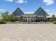 Exterior view of a blue clubhouse with white accents, offering a welcoming space for community gatherings and events at 18219 Ramble On Way, Land O Lakes, FL 34638