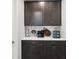 Coffee bar area with dark cabinetry, light countertop, and coffee-themed decorations at 18219 Ramble On Way, Land O Lakes, FL 34638