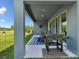 Covered outdoor patio featuring a grill and outdoor seating with lawn views at 18219 Ramble On Way, Land O Lakes, FL 34638