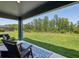 Covered patio with a chair set overlooking the backyard and nature at 18219 Ramble On Way, Land O Lakes, FL 34638