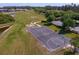 Overhead shot of a community basketball court, a playground, and a pond surrounded by lush green grass at 19407 Sweet Grass Way, Lutz, FL 33558