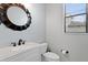 Bathroom featuring a vanity with a white countertop, toilet, and decorative mirror at 19407 Sweet Grass Way, Lutz, FL 33558