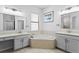 Elegant bathroom featuring dual vanities, a soaking tub, and a separate shower area at 19407 Sweet Grass Way, Lutz, FL 33558