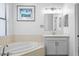 Bright bathroom featuring a soaking tub and a vanity with neutral cabinetry and countertop at 19407 Sweet Grass Way, Lutz, FL 33558