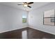 Bedroom featuring hardwood floors, neutral walls, and bright, natural light from two large windows at 19407 Sweet Grass Way, Lutz, FL 33558