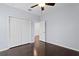 Bright bedroom featuring hardwood floors, a ceiling fan, and a spacious double-door closet at 19407 Sweet Grass Way, Lutz, FL 33558