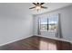 Bright bedroom featuring hardwood floors, a ceiling fan, and natural light from a large window at 19407 Sweet Grass Way, Lutz, FL 33558