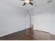 Bright bedroom featuring hardwood floors, a ceiling fan, and a spacious double-door closet at 19407 Sweet Grass Way, Lutz, FL 33558