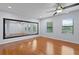 Spacious bonus room features wood floors, large mirror, and two large windows for natural lighting at 19407 Sweet Grass Way, Lutz, FL 33558