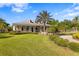 An eye-level view of the clubhouse with a large lawn and palm trees at 19407 Sweet Grass Way, Lutz, FL 33558