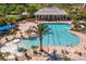 Overhead view of a community pool with a splash pad, lounge chairs, and palm trees near the community clubhouse at 19407 Sweet Grass Way, Lutz, FL 33558