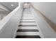 Stairway featuring hardwood stairs with white risers and a natural-toned handrail at 19407 Sweet Grass Way, Lutz, FL 33558