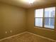 A neutral bedroom features a window, wall sockets and beige carpet at 2002 E 5Th Ave # 110, Tampa, FL 33605