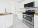Modern kitchen features stainless steel appliances, sleek white cabinetry, and butcher block countertops at 201 W Laurel St # 504B, Tampa, FL 33602