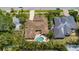 Aerial view of a home highlighting its tile roof, private pool, lush landscaping, and neighborhood setting at 206 Corbett St, Belleair, FL 33756