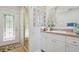 Well-lit bathroom featuring a glass block shower, vanity, and stylish fixtures at 206 Corbett St, Belleair, FL 33756