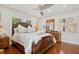 Bedroom with hardwood floors, ceiling fan, windows, and decorative furniture at 206 Corbett St, Belleair, FL 33756