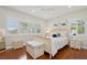 Bedroom featuring a white wicker bed frame, hardwood floors, and natural lighting at 206 Corbett St, Belleair, FL 33756