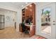 Dedicated home office with custom built-ins, a desk, and natural light from the nearby door at 206 Corbett St, Belleair, FL 33756