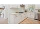 Modern kitchen with white cabinetry, gold hardware, and sleek countertops at 206 Corbett St, Belleair, FL 33756