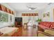 Spacious living room with hardwood floors, a ceiling fan, and natural lighting at 206 Corbett St, Belleair, FL 33756