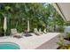 Relaxing patio area surrounded by lush tropical landscaping and plenty of seating for guests at 206 Corbett St, Belleair, FL 33756