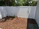 Backyard area showcases fresh mulch and a white privacy fence with a gate at 2205 N Grady Ave, Tampa, FL 33607