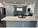 Bright kitchen featuring white cabinets, stainless steel appliances, and a stylish backsplash at 2205 N Grady Ave, Tampa, FL 33607