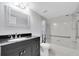 Bathroom featuring modern vanity, mirror, and tub with shower and grab bar at 2231 Utopian E Dr # 117, Clearwater, FL 33763
