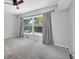 Bedroom featuring neutral carpet, gray walls, a large window, and a dark ceiling fan at 2231 Utopian E Dr # 117, Clearwater, FL 33763
