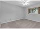 Neutral bedroom featuring gray walls, carpet, a ceiling fan, and a window bringing in natural light at 2231 Utopian E Dr # 117, Clearwater, FL 33763