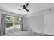 Bedroom featuring neutral carpet, gray walls, a large window, dark curtains and ceiling fan at 2231 Utopian E Dr # 117, Clearwater, FL 33763