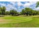 Scenic golf course view with manicured green and beautiful landscaping under a blue sky with light clouds at 2231 Utopian E Dr # 117, Clearwater, FL 33763