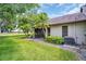 Home's backyard with mature palm trees, a screened in patio, and well-manicured lawn at 2506 Laurelwood Dr # 4C, Clearwater, FL 33763