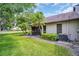 Home's backyard with mature palm trees, a screened in patio, and well-manicured lawn at 2506 Laurelwood Dr # 4C, Clearwater, FL 33763